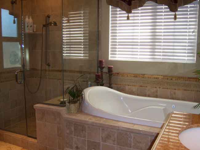 Picture #13 (Shower/tub) Frameless shower glass allows you to see the beauty in this travertine installation.  Notice the mosaic tile and moulding feature that caps the tub splash and continues into the shower stall.  Sometimes this feature can also be the same height as the backsplash for the vanity, creating a level line around the entire perimeter of the bathroom.